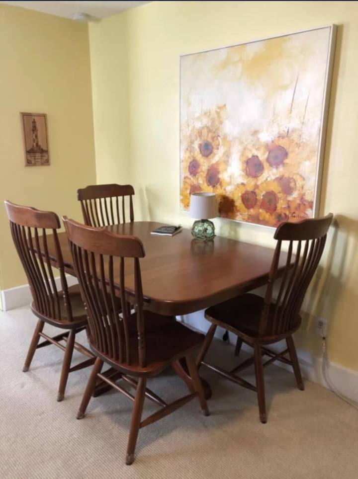 Dining area with wood table and sunflower art